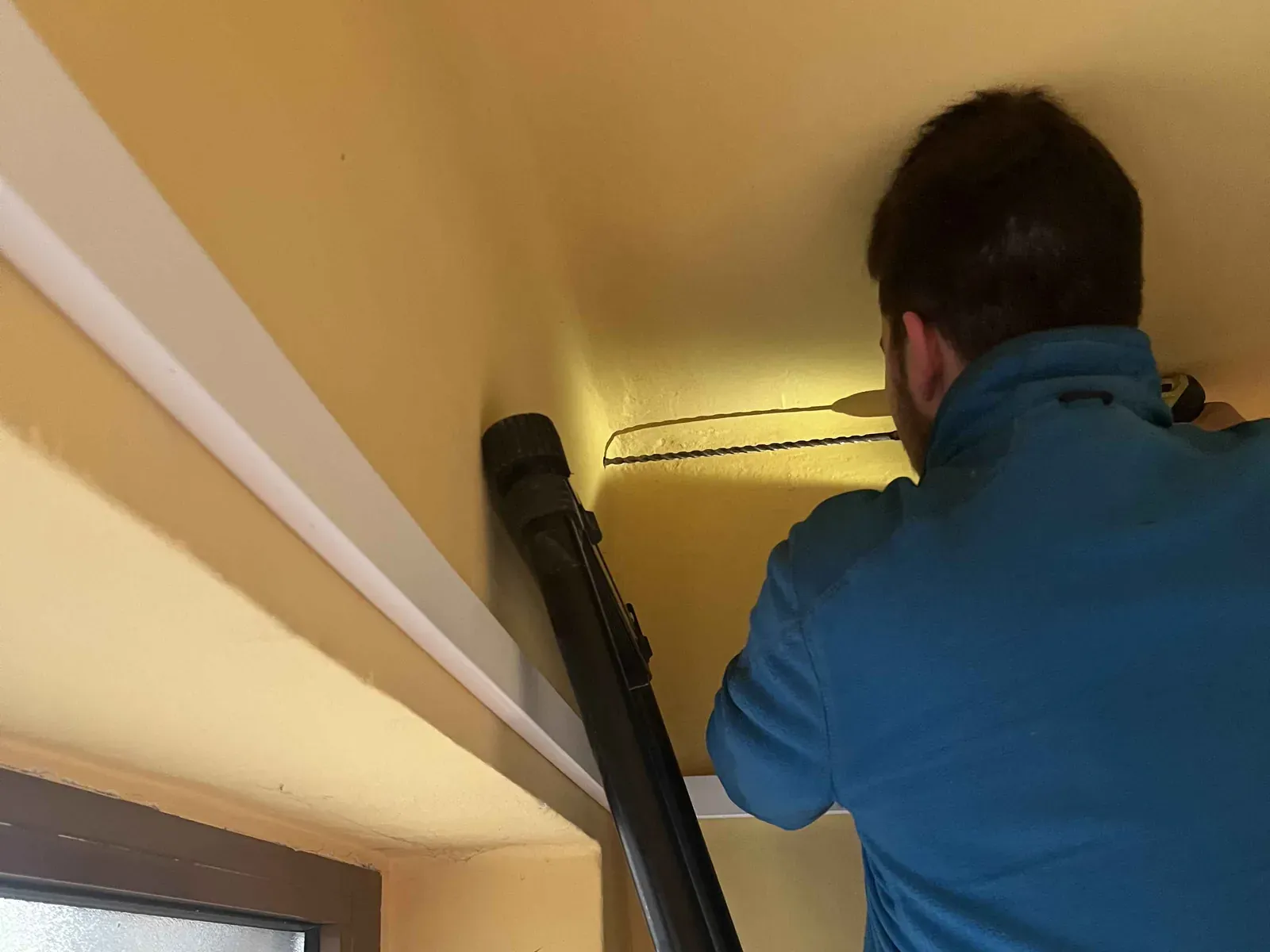Technik vrtá průraz na druhou stranu pro kameru u vchodu