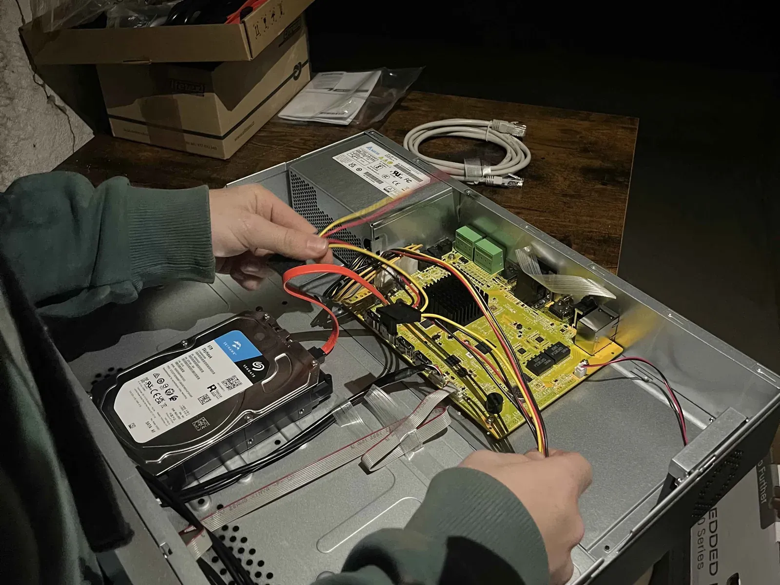 Technik zapojuje disk do záznamového zařízení kamerového systému